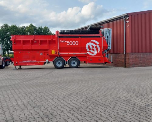 Mobile Trommelmaschine Siebo 5000 im Transportzustand vor dem Betriebsgelände von Manfred Ende – Baustoffhandel & Transporte.